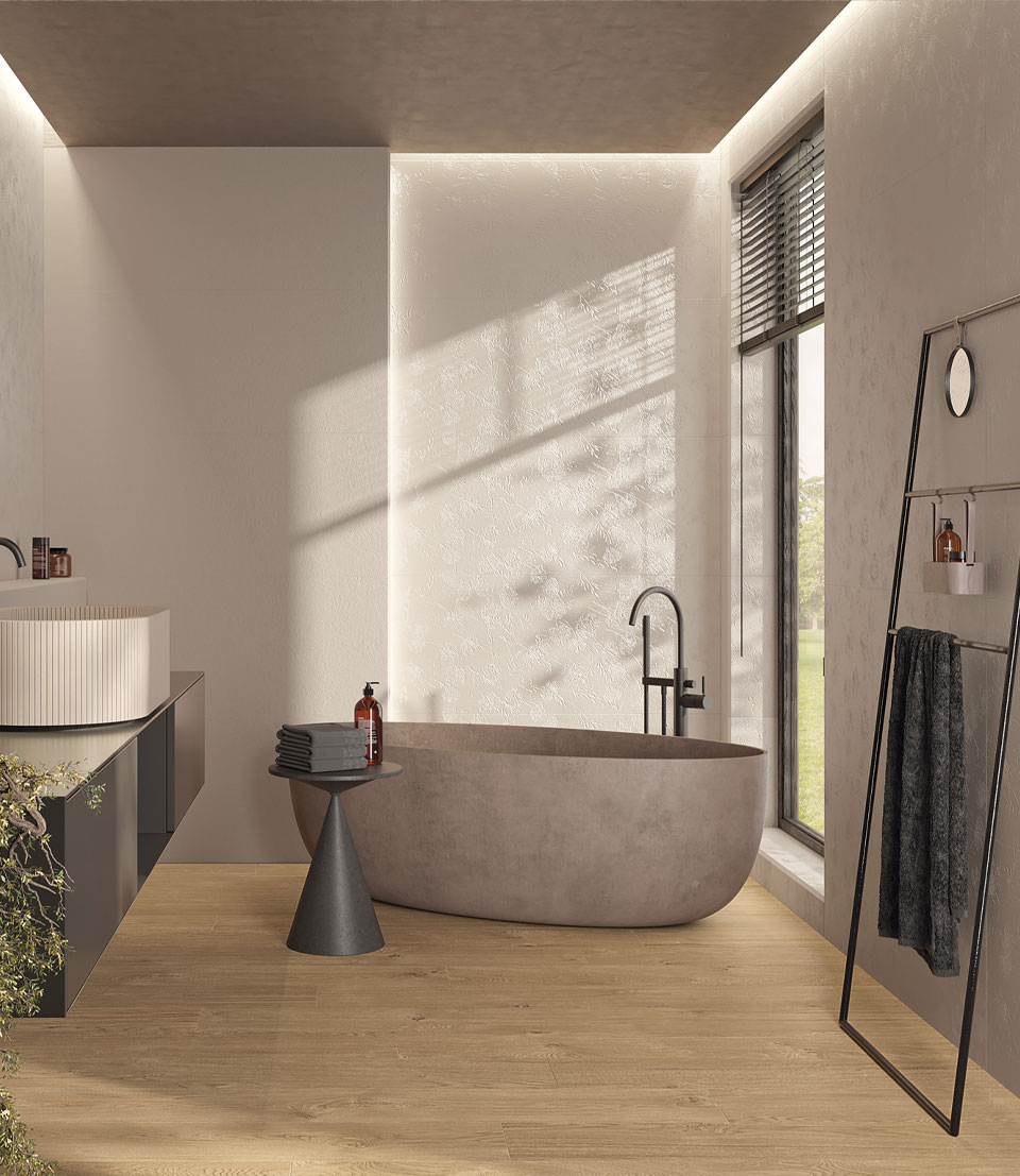 Modern bathroom with light textural wall tiles, oval tub in cement finish, wood-effect floor, minimal black furniture.