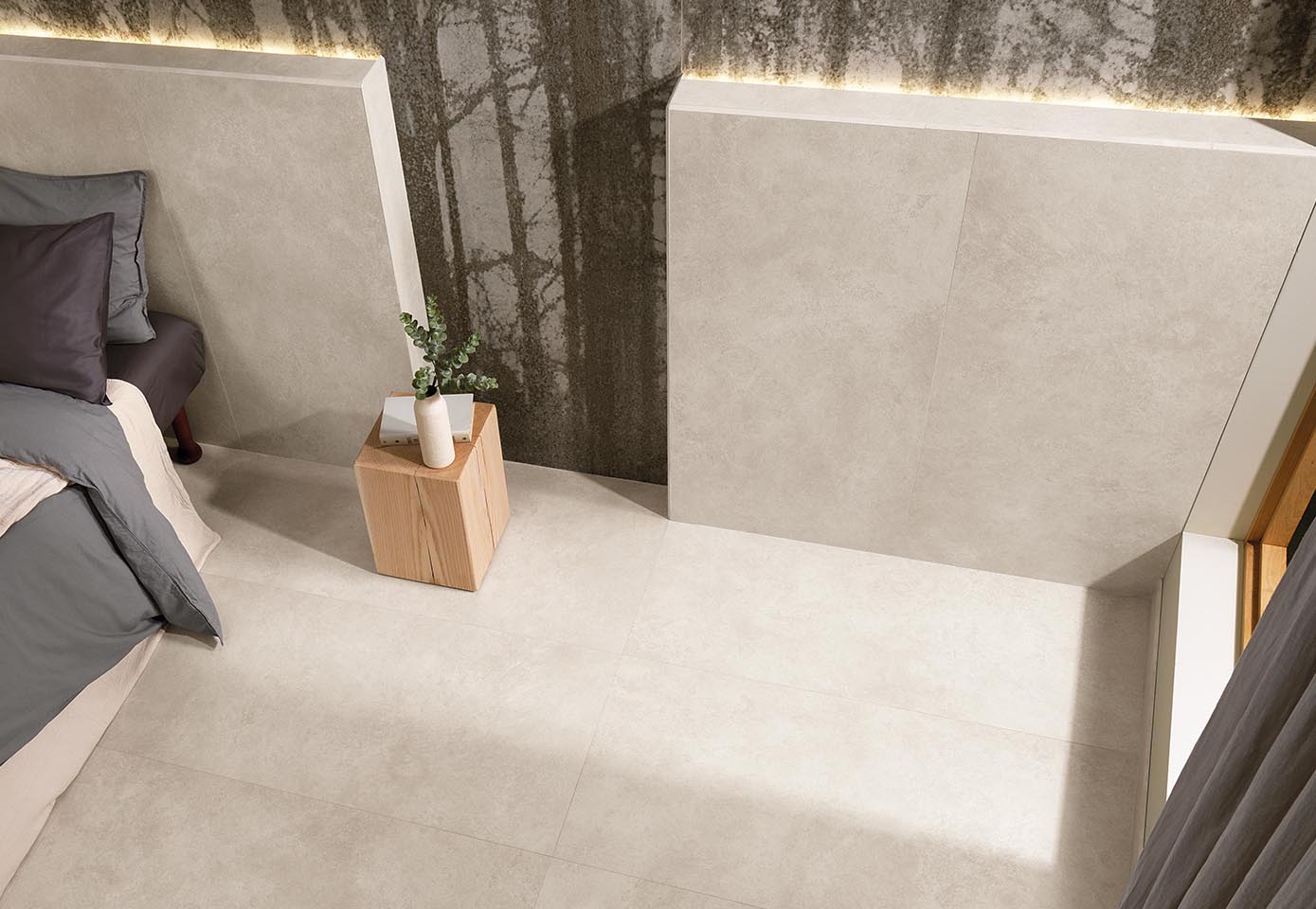 Detail of bed headboard and floor in beige stone-effect porcelain stoneware and large wood-effect slab covering.