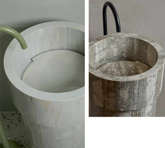 Freestanding cylindrical washbasins in textured ceramic, grey and green finishes with contrasting black and matt green taps.