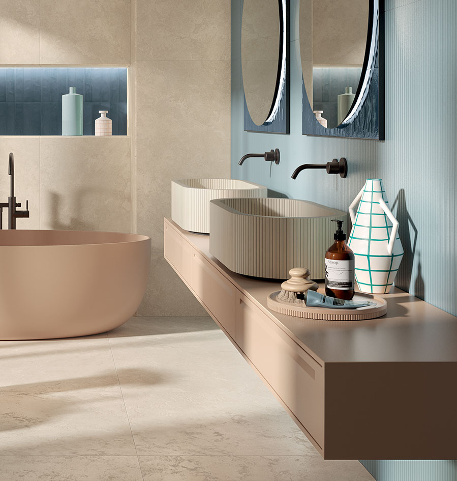Double oval washbasin in light ceramic with vertical texture, beige suspended top, free-standing basin and blue and grey walls.