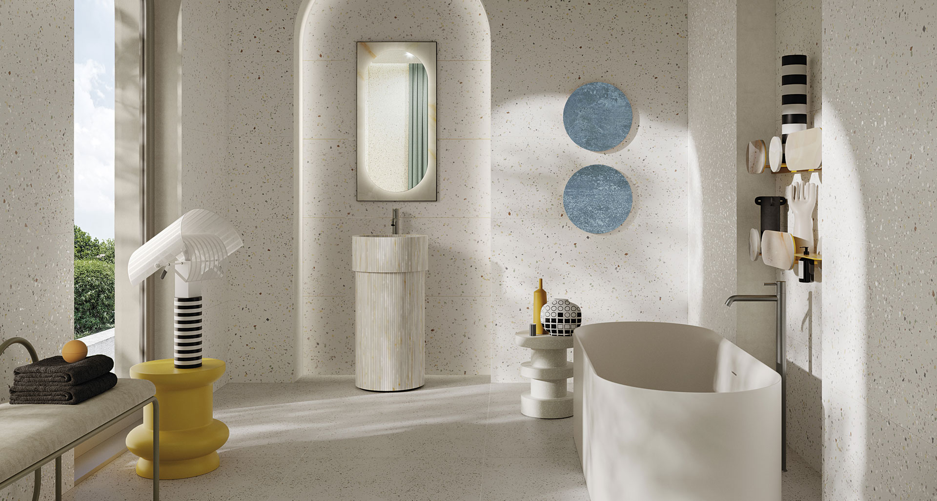 Modern bathroom with light terrazzo-effect stoneware surfaces, striped cylindrical washbasin, freestanding opaque bathtub, and furniture with sculptural and decorative design.