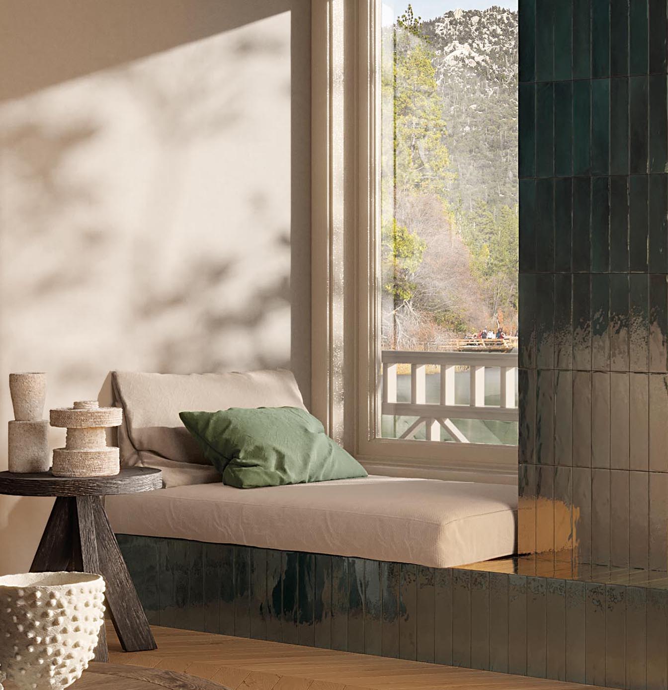 Relaxation area with dark green glazed brick effect ceramic seat and wall tiles, and wood effect floor.