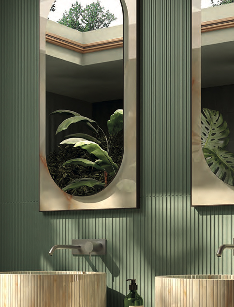 Shaped mirrors with gold edging reflect the green of the plants on a wall covered in sage green ceramic slats.
