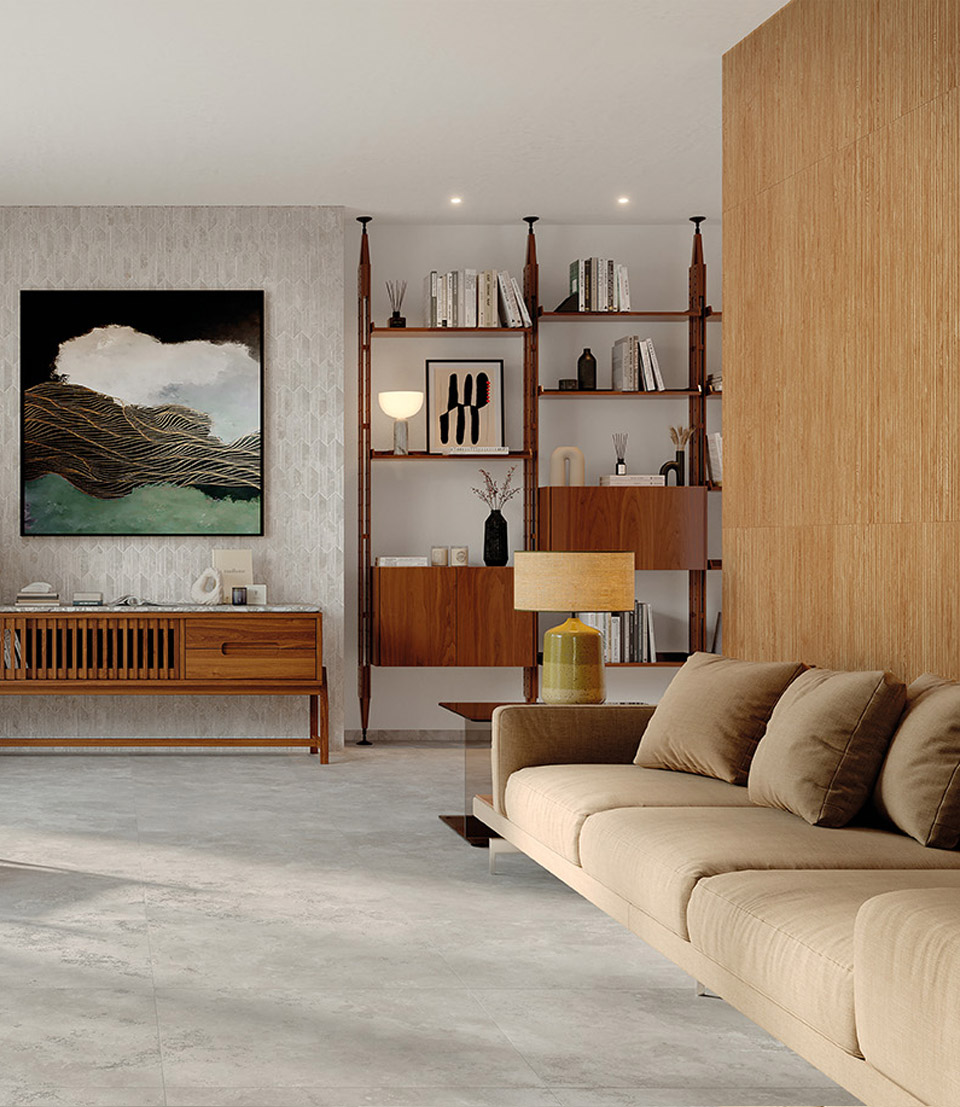 Living room with grey material-effect stoneware walls, light-coloured floor and natural wood furniture beige fabric sofa, objects, large bookcase.
