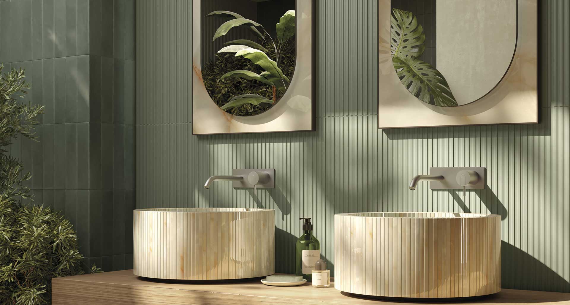 Bathroom with green ceramic wall tiles, onyx-effect striped sinks and oval mirrors in clear frame with elegant design.