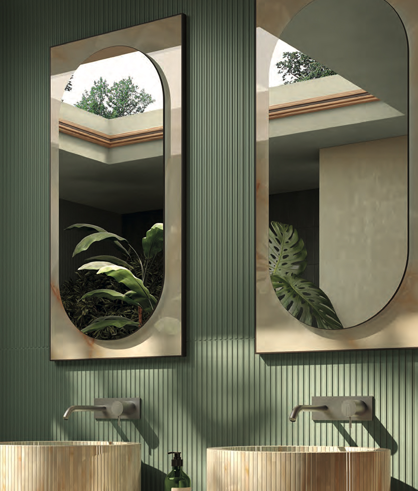 Shaped mirrors with golden edges reflect the green of the plants on a wall covered in sage green ceramic slats.