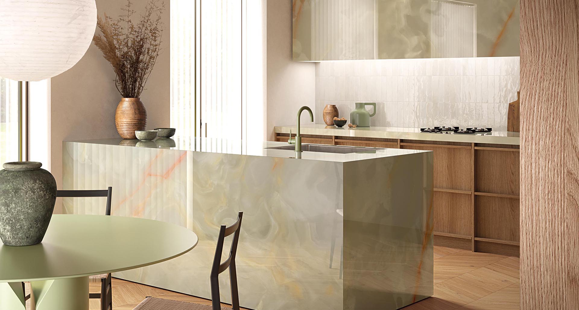 Kitchen with island covered in green onyx-effect stoneware, natural wood furniture, green round table and brown chairs.