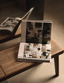 Open photo book on a wooden and Vienna straw bench, on beige concrete-effect porcelain stoneware flooring.