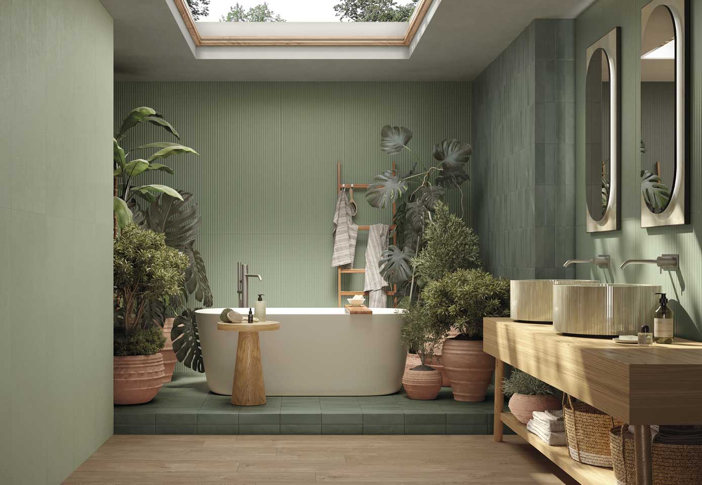Bathroom with sage green ceramic wall tiles, green slatted wall, freestanding bathtub and ornamental plants, light wood effect floor, double sink and double mirror on wood effect ceramic countertop.