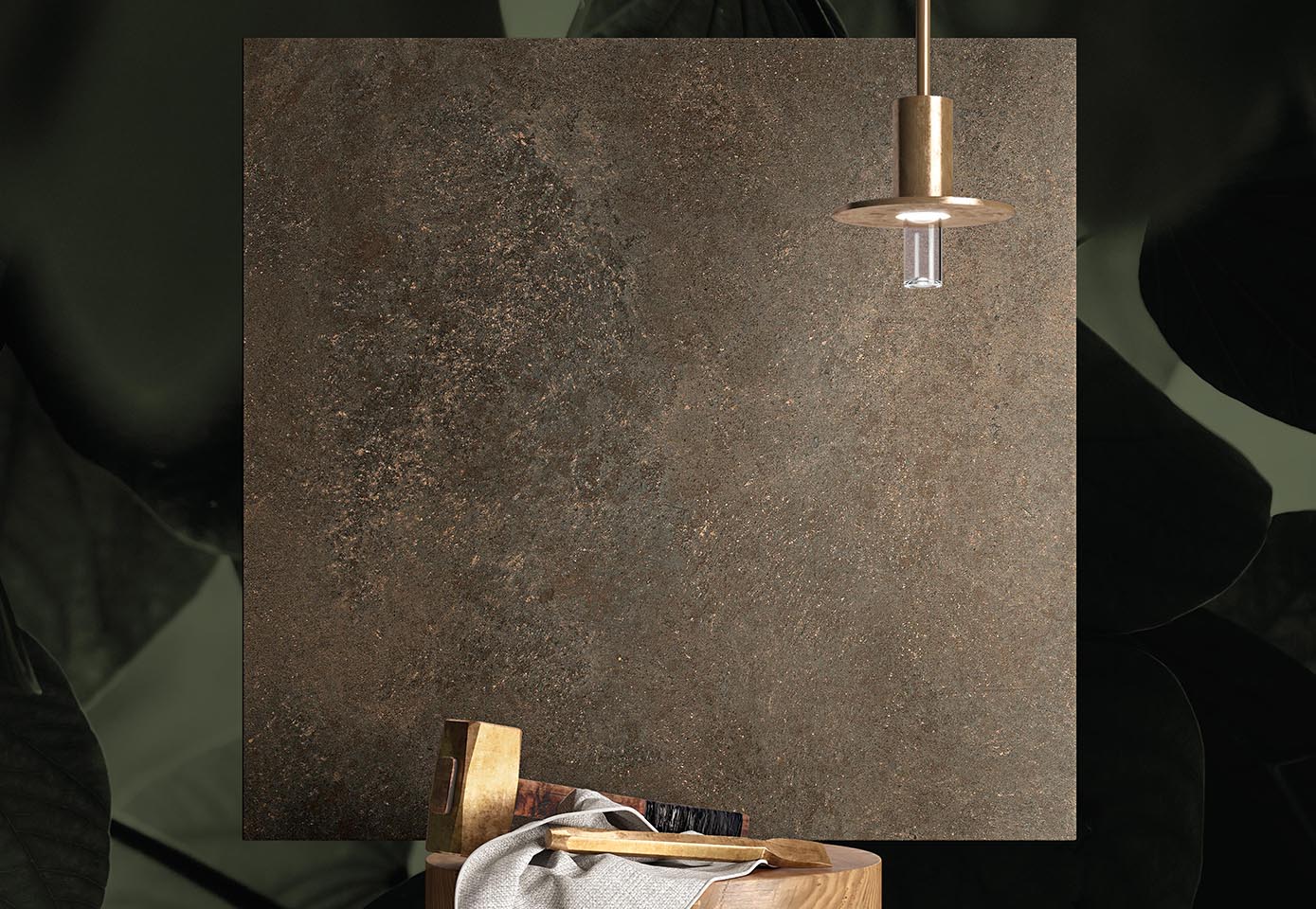 Grey stone effect tile with metallic highlights, lit by suspended brass lamp, leaning on wooden stool.