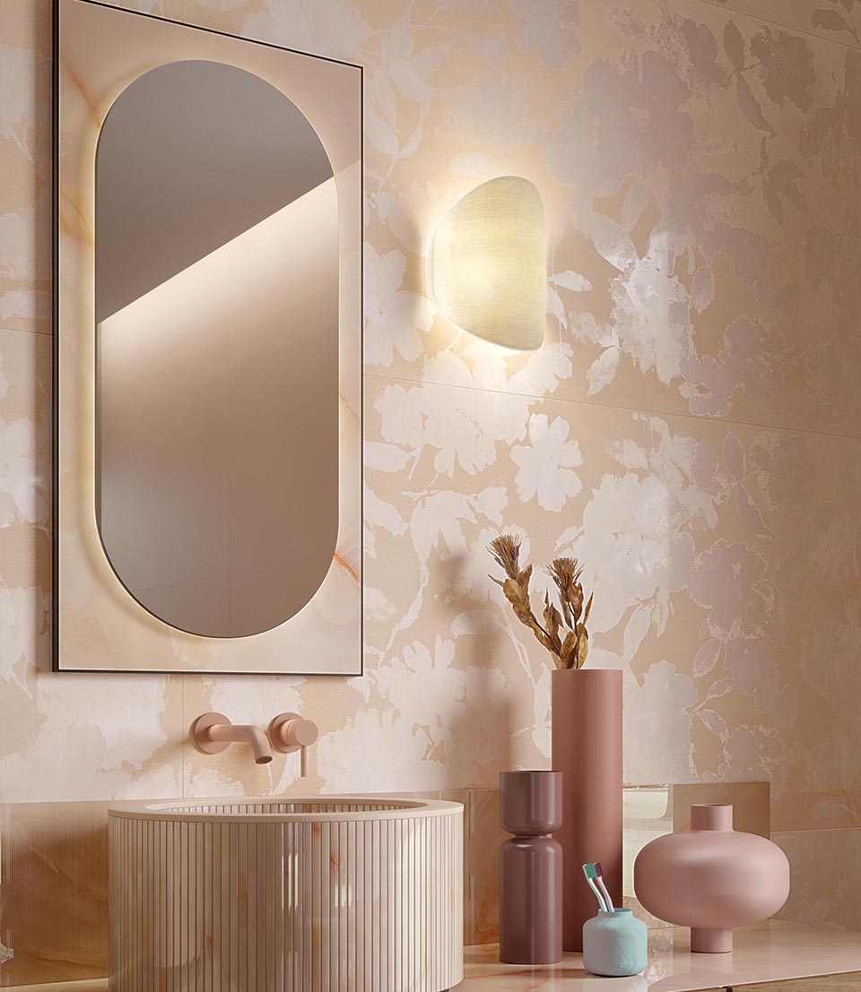 Bathroom with grooved cylindrical washbasin, tone-on-tone beige floral walls and pink and brick ceramic accessories.