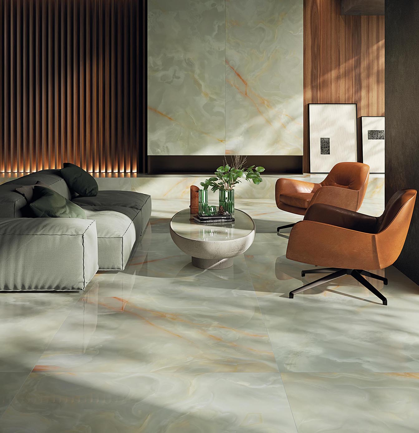 Living area with green onyx-effect floor and wall tiles with orange veins, leather-coloured leather armchairs, grey fabric sofa, central oval coffee table.