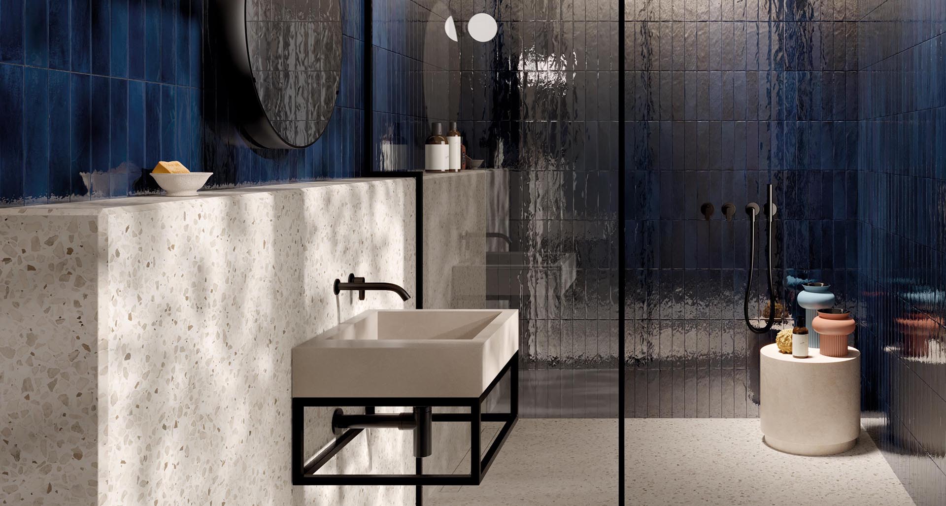 Modern bathroom with glossy blue brick-effect ceramic walls, wall-hung sink, and shower with matte black faucets.