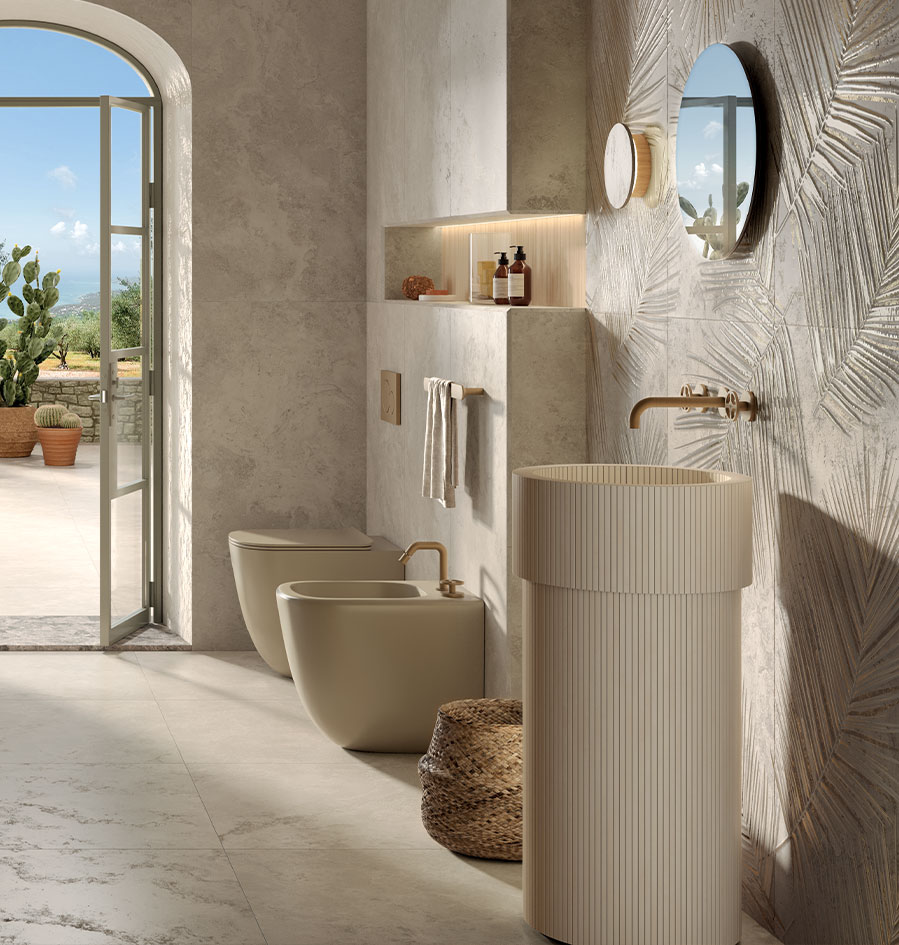 Bright bathroom with beige cylindrical freestanding washbasin, stone-effect cladding and embossed leaf tiles, gold details.