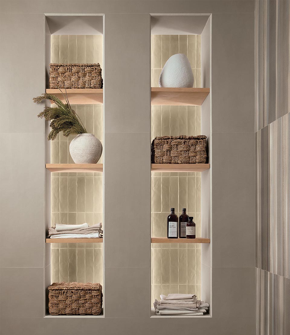 Wall with backlit niche shelves with shiny beige brick-effect tiles, wicker baskets and natural contrasting ceramic accessories