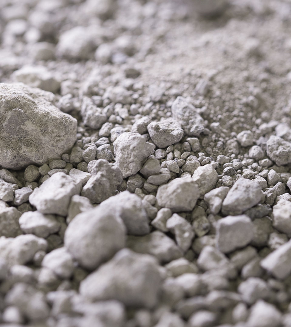 Detail of mineral fragments and powders in neutral tones, essential raw materials for environmentally friendly ceramics.