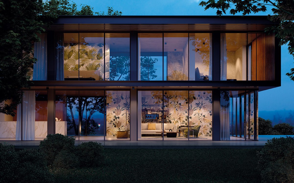 Glass façade of a contemporary house with interiors decorated with tropical tiles illuminated at sunset.