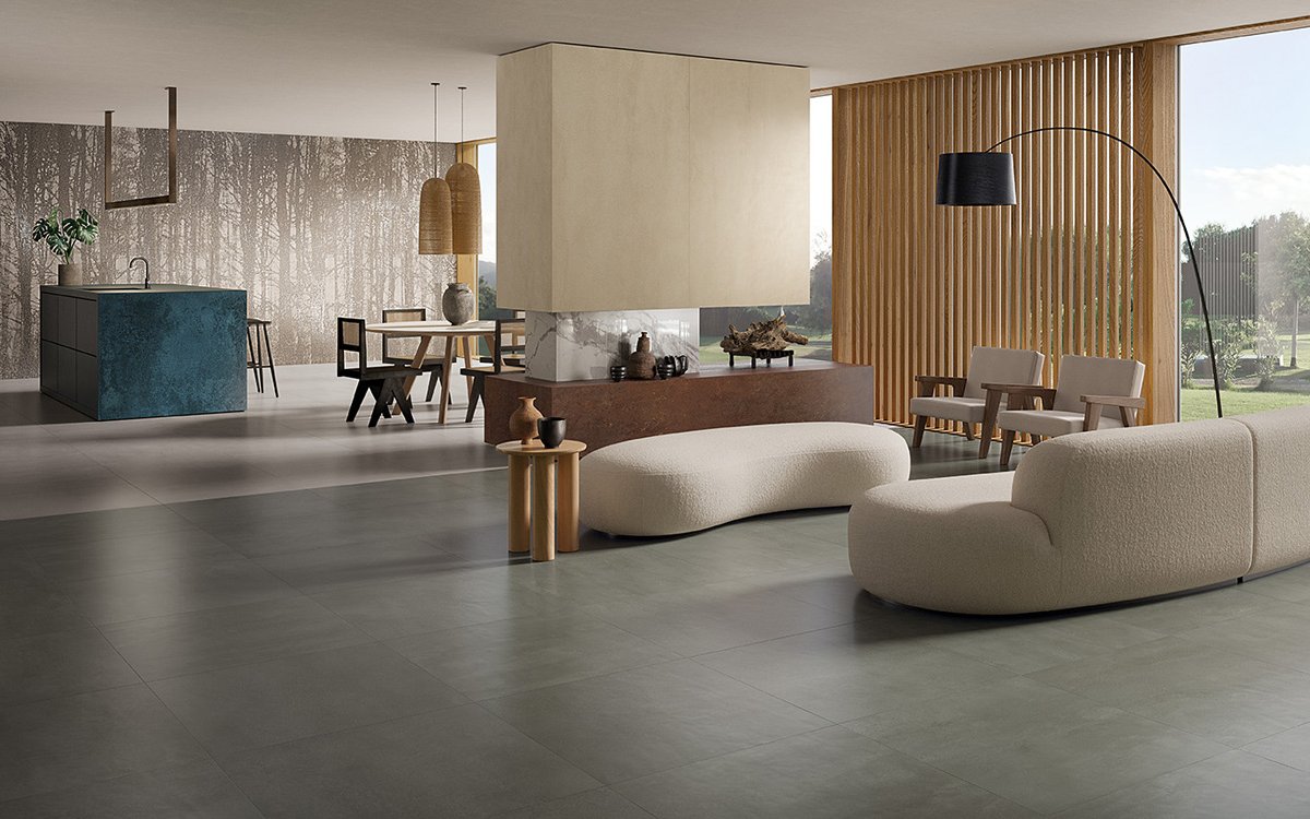 Modern living room with grey concrete-effect flooring, forest-themed walls and light wood furniture and natural fabrics.