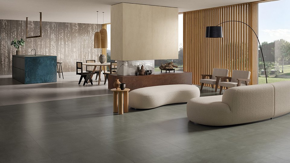 Modern living room with grey concrete-effect flooring, forest-themed walls and light wood furniture and natural fabrics.