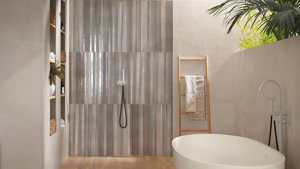 Contemporary bathroom with beige walls and glossy striped shower cladding, wood-effect flooring, and white bathtub.