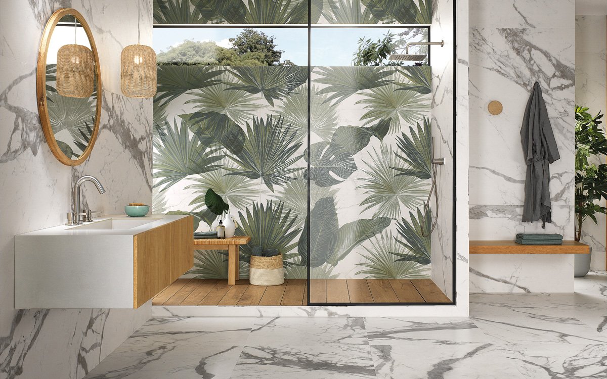Modern bathroom with white marble effect wall tiles and shower wall decorated with tropical green leaves.