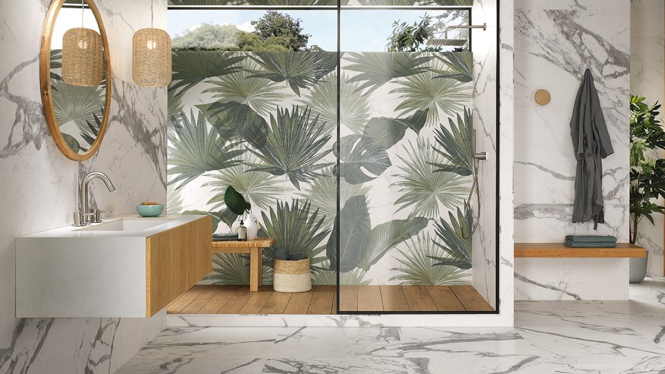 Modern bathroom with white marble effect wall tiles and shower wall decorated with tropical green leaves.