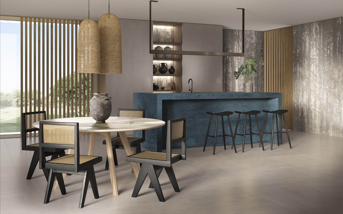 Elegant kitchen with blue metal-effect island, neutral walls and woodland wallpaper, wooden and rattan furnishings.
