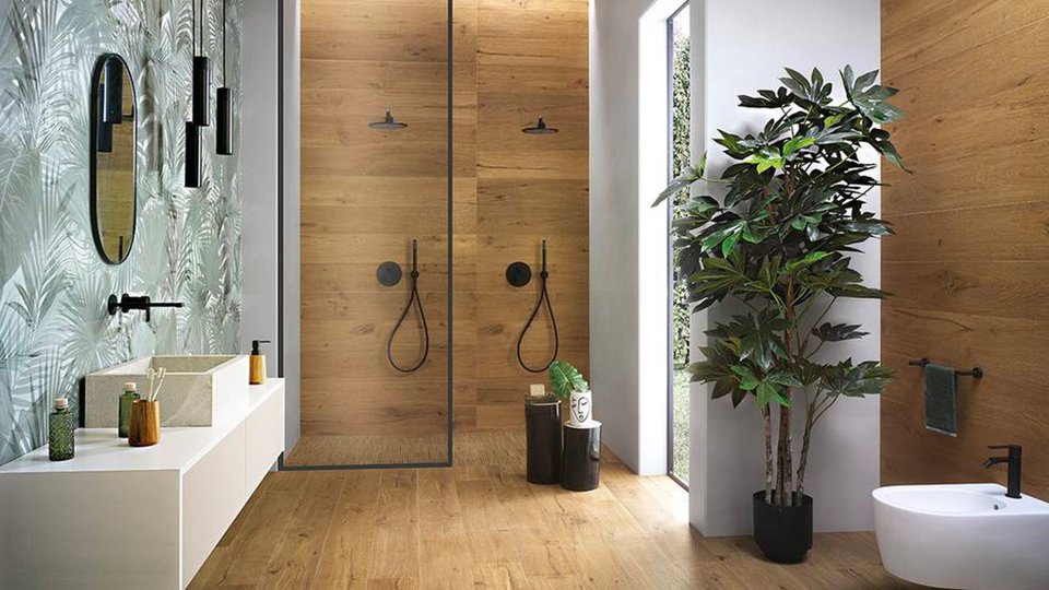 Modern bathroom with wood-effect walls and tropical décor, white wall-mounted washbasin and matt black details.