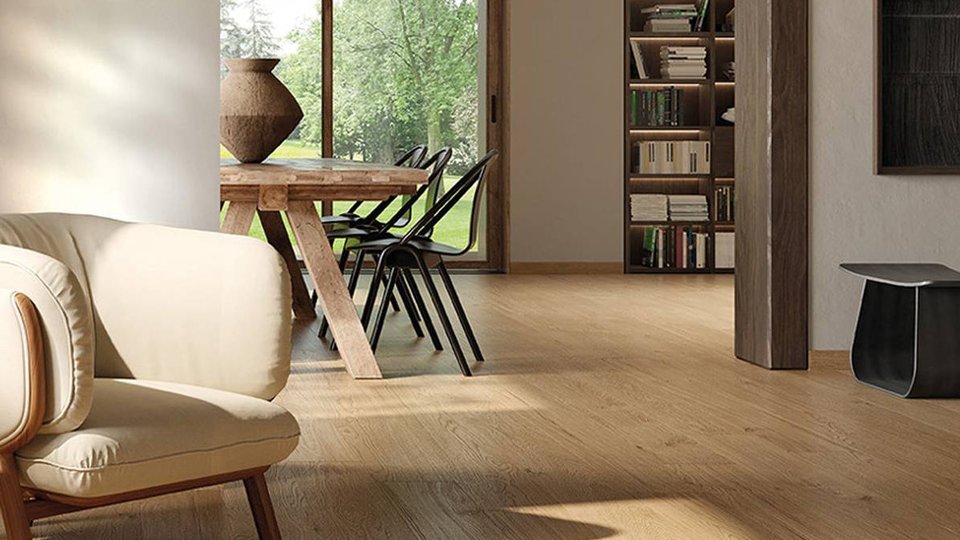 Natural living room with light wood-effect flooring, solid wood furniture and large windows overlooking the garden.