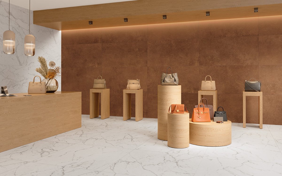 Elegant boutique with rust-coloured walls and veined white marble, marble-effect stoneware flooring and light wood furnishings.