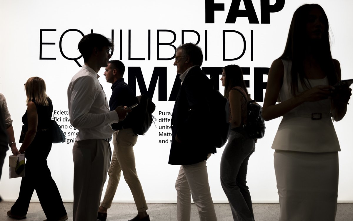 Persone durante evento FAP Ceramiche davanti alla scritta “Equilibri di Materia”, in uno spazio espositivo luminoso e moderno.