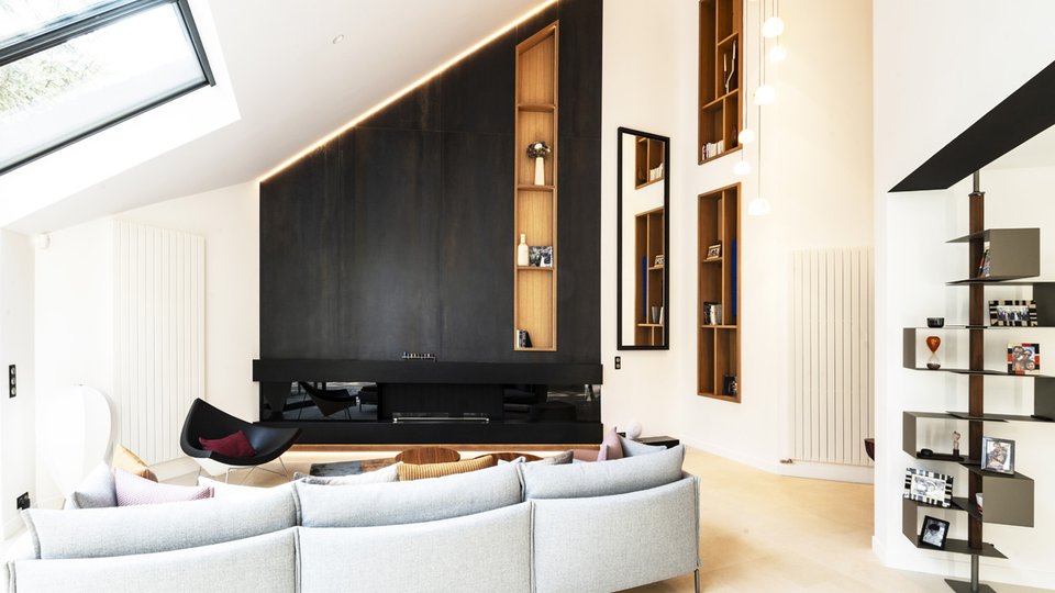Contemporary living room with white walls and dark paneling, gray sofa, and bright details for an elegant, minimalist design.
